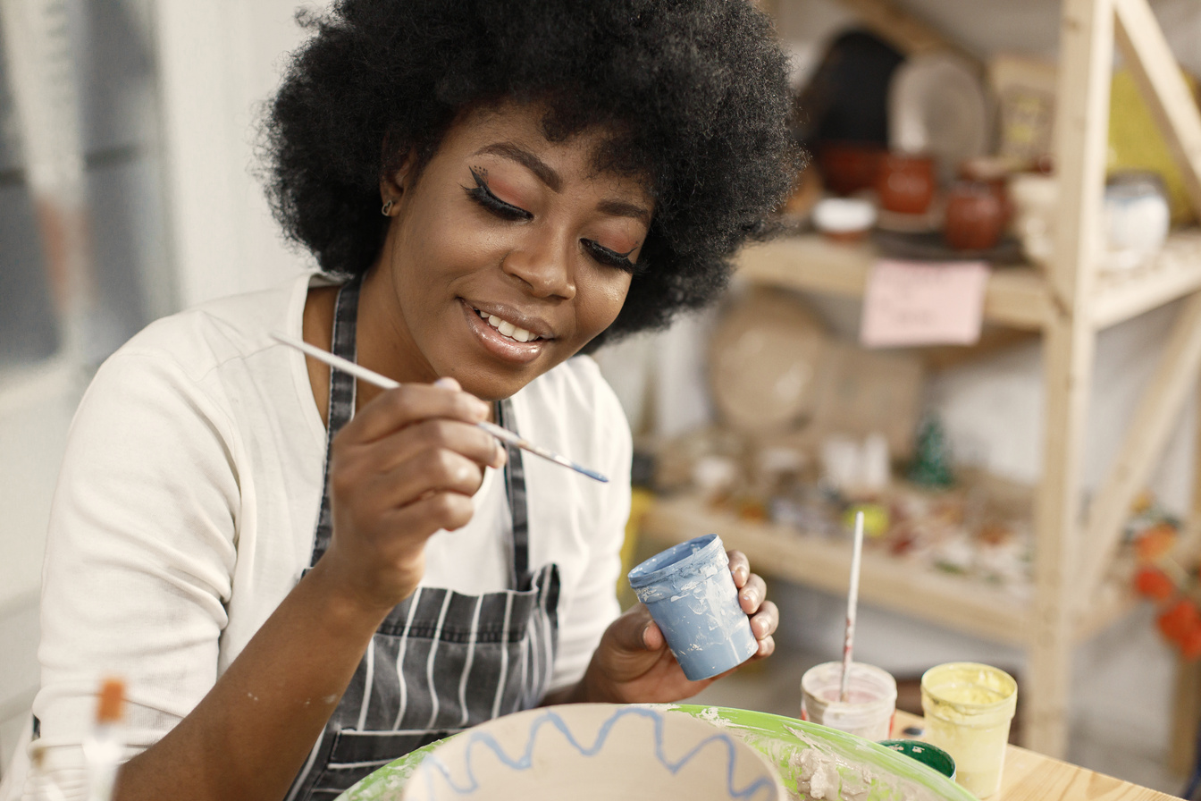 Young Woman Painting Clay Pot